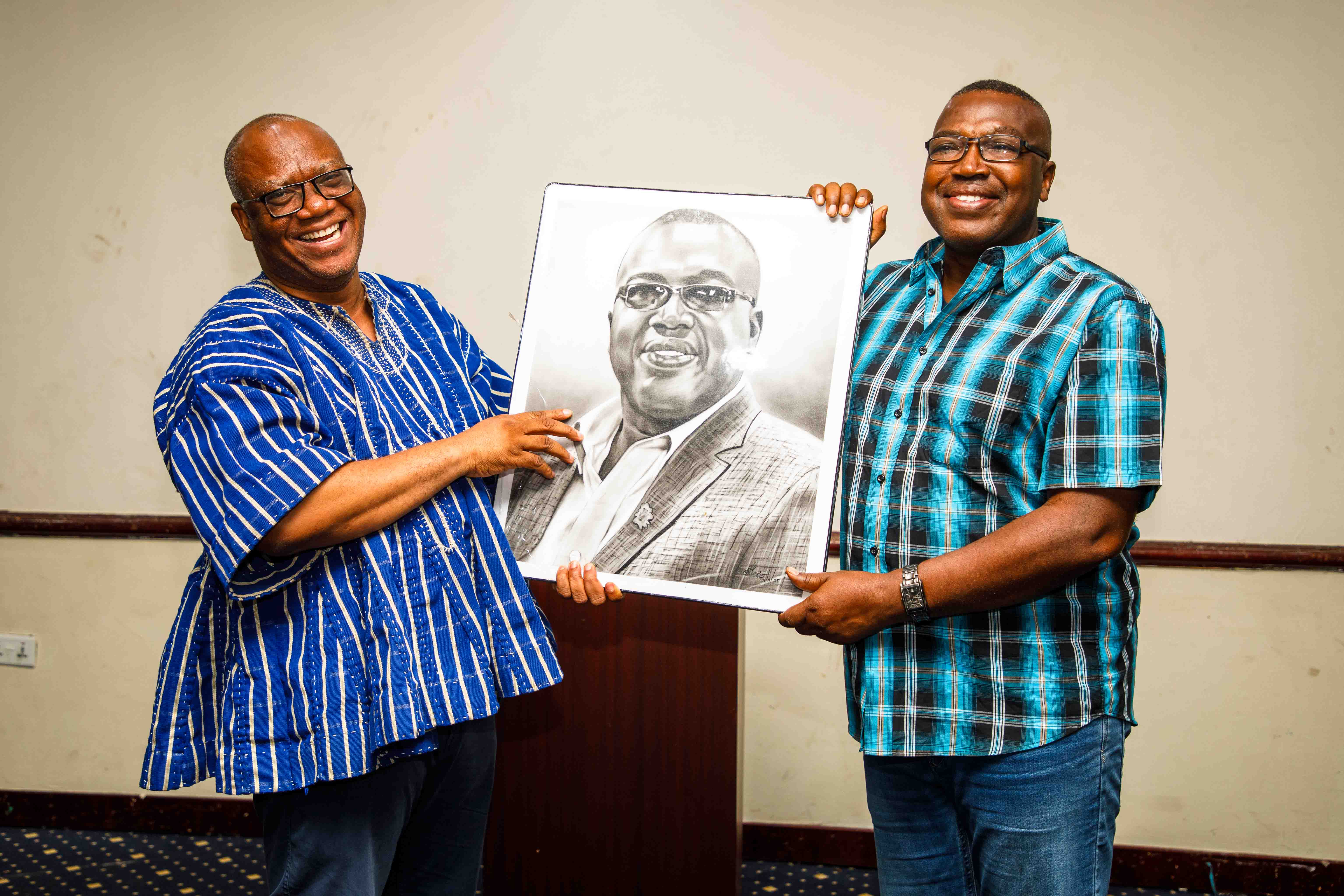 Prof. Jerry John Kponyo, the Project Lead for KEEP, happily presents a portrait to Dr. Ben Asante.