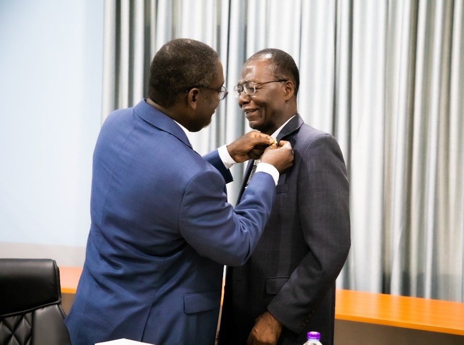 Provost of College of Engineering decorating Prof. Yeboah with a KNUST brooch  